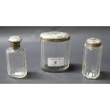 Three repoussé-decorated, hallmarked silver-mounted glass dressing jars.