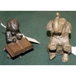 A bronzed metal seated infant with an incorporated book-form Vesta case,