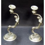 A pair of white metal figural candlesticks.