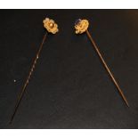 Two gold decorative stick pins plus a set of gold earrings