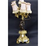 In the manner of Clodion, a bronze and marble table lamp, five sconce raised by a figural putti,