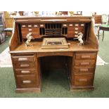 A 1920s twin-pedestal roll-top desk with a fitted interior, panelled sides and modesty panel (for