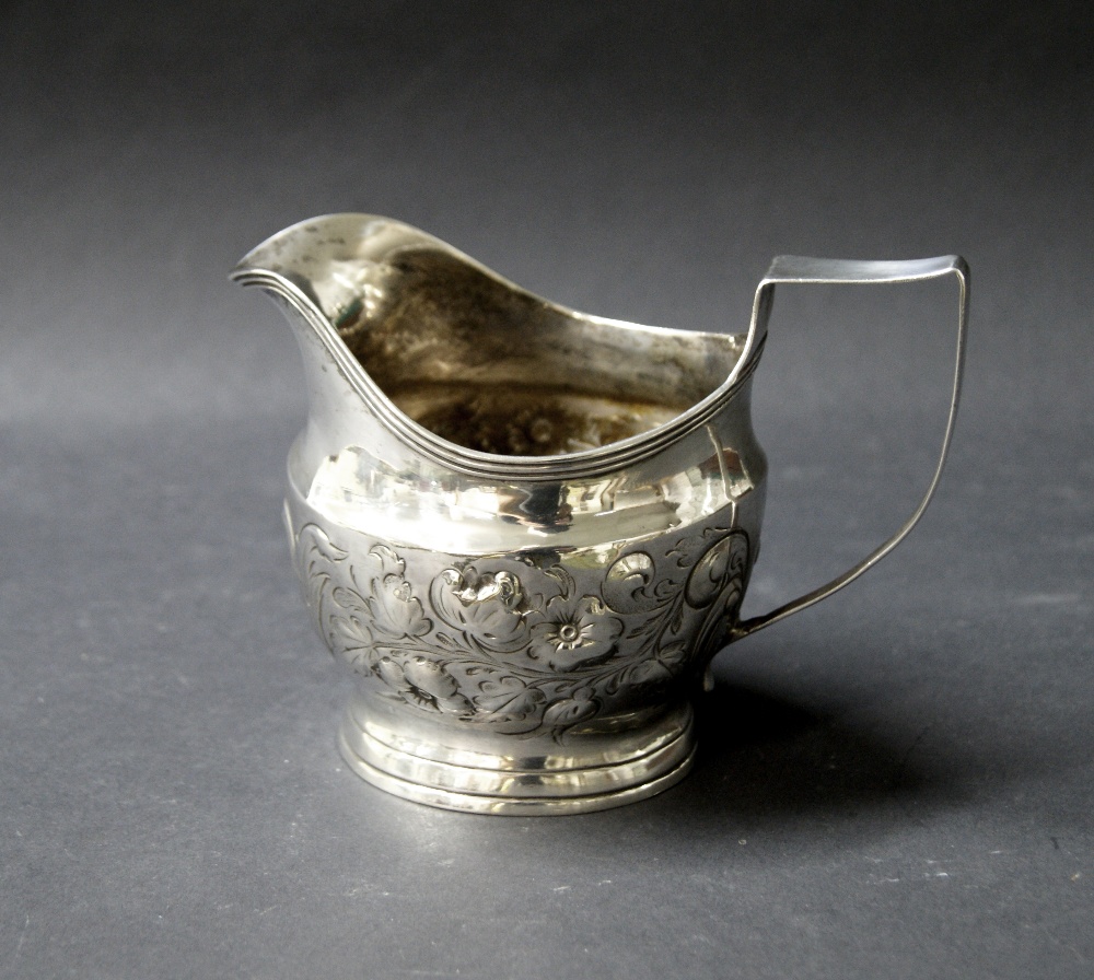 Georgian hallmarked silver jug with repoussé decoration.