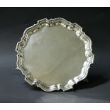 A hallmarked silver salver with a raised scalloped edge, uninscribed.