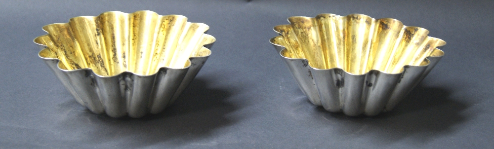 A pair of continental white metal lobed bowls, each having a gilt-washed interior.