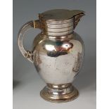 An early 19th century silver plated footed ewer, having a hinged cover over a Bacchus mask cast