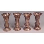 A set of four 19th century English silver specimen vases, each of embossed trumpet form and on