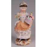 A Meissen porcelain figure of a girl with her doll, in standing pose wearing crinoline lined shawl