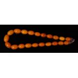A beaded butterscotch amber single string necklace, having 21 graduated oval beads, the largest w.