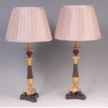 A pair of 19th century bronze and gilt bronze table candlesticks, each later converted into lamps,