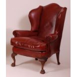 A Georgian style beechwood framed and leather upholstered wing armchair,