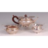 A late Victorian silver three piece teaset, comprising; teapot, twin handled sugar and cream, each