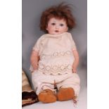 An Armand Marseille 971 bisque headed doll, having rolling blue eyes, painted features,