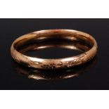 A ladies 14ct gold hinged bangle, having bright cut engraved leaf decoration, 9.7g, dia.6.