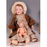 An Armand Marseille 390 bisque headed doll, having composition body and jointed limbs, flirty eyes