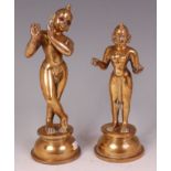 A pair of Indian heavy brass figures of Krishna and Radha, each raised upon domed circular