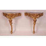 A pair of circa 1860 rococo revival giltwood and gesso marble topped console tables,