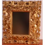 An 18th century giltwood and gesso Florentine frame, with later inset mirrorplate, the swept frame