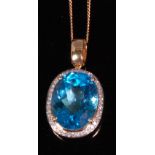 A contemporary 14ct yellow gold blue topaz and diamond set pendant,