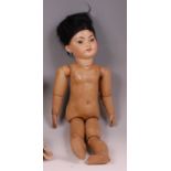 A circa 1900 continental bisque headed doll of an Oriental child, having composition body, flirty
