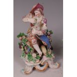 An 18th century Bow figure of Autumn, modelled as a vintner seated upon an upturned basket of