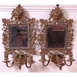 A pair of late 19th century brass framed mirror reflectors, each with grotesque mask,