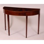 A George III mahogany demi-lune card table, having fold-over top on gateleg rear action,