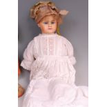 An early 20th century composition baby doll, having fixed blue eyes, painted features and jointed