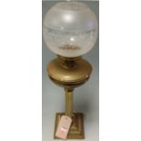 A circa 1900 lacquered brass pedestal oil lamp with shade