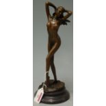 A reproduction bronze figurine of a standing female nude