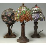 A Tiffany style bronzed metal table lamp with glass shade and two other similar (3)