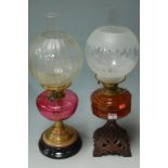 A late Victorian cast metal pedestal oil lamp with glass reservoir;