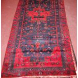 A Persian woollen rug, the blue ground decorated with stylised trees,