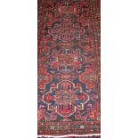 A semi-antique Persian woollen rug, having a medallion field within a complex trailing border,