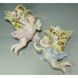 A pair of modern continental porcelain wall pockets in the form of cherubs