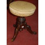 A Victorian carved walnut revolving piano stool