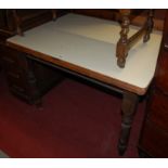 A Victorian stained pine and later formica topped round cornered kitchen table