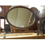 A mahogany oval swing toilet mirror