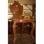 A Victorian oak hall chair, having a shield shaped back above a solid seat,