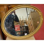 A late 19th century giltwood framed oval wall mirror, together with a beech single side chair (2)