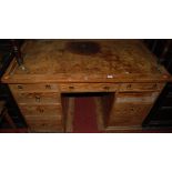 A Victorian pitched pine and gilt tooled tan leather inset kneehole writing desk