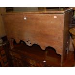 An antique boarded elm hinge top coffer having a wavy carved lower edge