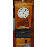 An early 20th century oak cased clocking-in and out machine by The Time Recorder Supply &