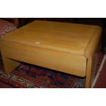 A contemporary light oak two drawer coffee table