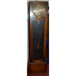 A 1930s oak long case clock having a glazed trunk door,