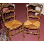 A set of three late 19th century French beech ladderback rush seat kitchen chairs;