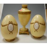 A modern Italian porcelain pedestal vase with two matching decorative eggs with pate-sur-pate