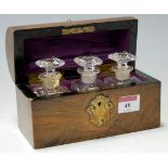 A Victorian figured walnut dome topped dressing table box containing three bottles and stoppers