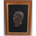 A bronze portrait plaque depicting Adolf Hitler in profile,