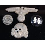 A German Waffen SS spread eagle cap badge, together with three others.